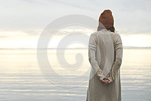 Lonely woman looks at the infinite in the hope of a better future