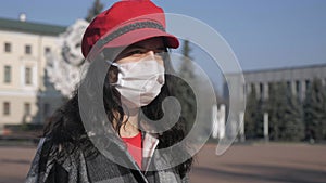 A lonely woman in a medical protective mask in a deserted city. Virus epidemic in the city. Coronavirus.