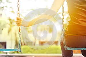 Lonely woman missing her boyfriend while swinging in the park villa in the morning