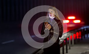 Lonely woman posing at dark highway