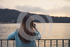 Lonely woman standing absent minded at the river