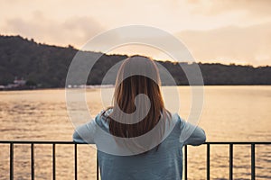 Lonely woman standing absent minded at the river