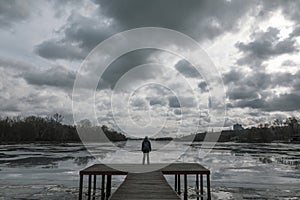 Lonely woman standinng on the wooden pier