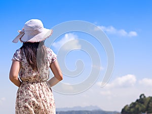 Lonely Woman in summer vacation wearing straw hat and beach dress