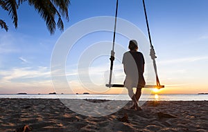 Lonely woman thinking about life on a beach at sunset