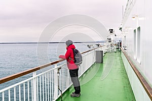 Lonely woman tourist on the deck of a ferry in navigation