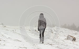 Lonely woman walking in the snow. Extreme weather in winter photo