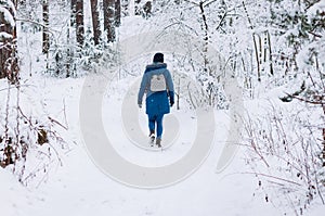 a lonely woman walks in a winter snowy forest. healthy lifestyle