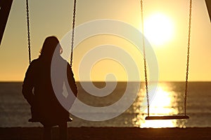 Lonely woman watching sunset alone in winter