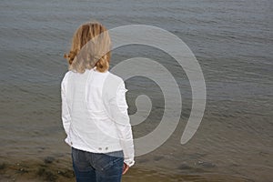 Lonely woman in white casual outfit with Blond hair sitting