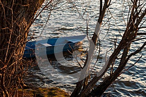 Lonely wooden fishing boat on lake at evenyng