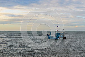 A lonely wooden fishing boat returns to the village after night catching at dawn