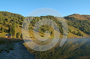 Lonely wooden house in the mountains near the lake