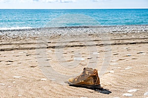 Lonely yellow boot on the seashore. washed ashore a boot