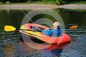 Lonely young boy fishing from inflatable boat on