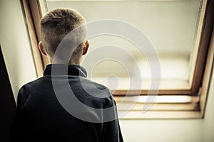 Lonely Young Boy Looking Through Glass Window