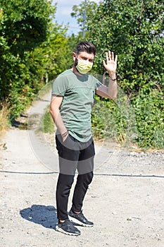 Lonely young gay with medical mask in the park