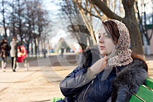 Lonely young woman sitting on a park bench