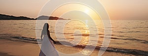 Lonely young woman walking and enjoying beautiful Sunset on the tranquil beach, Travel on summer vacation concept, Banner panorama