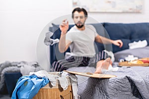 loner throwing dirty sock into basket with laundry