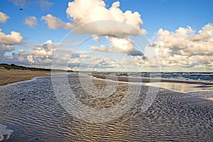 Lonesome beach of the Baltic Sea with blue sky and clouds