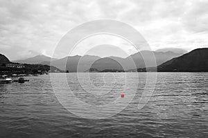 Lonesome sail boat with a red buoy in Lake Como in Italy,