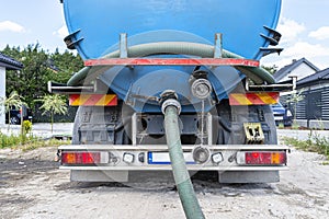 Long 4 inch PVC suction hose connected to the flange fitting on the trucks tank.