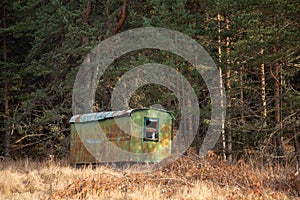 Long ago abandoned trailer forgotten in the woods high contrast autumn landscape with copy space for text advert