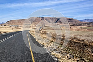 Long Asphalt Road Stretching through Dry Winter Landscape