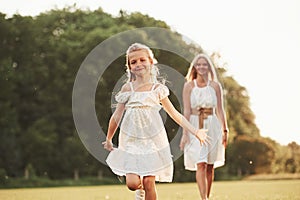 Long-awaited meeting. Mother and daughter enjoying weekend together by walking outdoors in the field. Beautiful nature