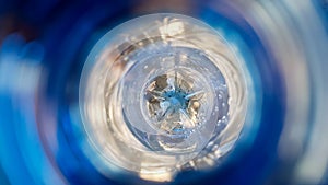Long background with a plastic blue bottle with water drops inside