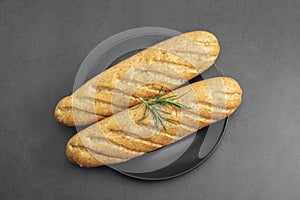 Long Baguette bread isolated on black dish, bread for sandwich. Top view