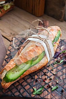 Long baguette sandwich with beef steak slices cucumber and spice