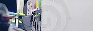 Long Banner for the fuel industry. A gas hose is installed in a car at a night gas station with a store in the background and