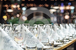 A long banquet table with wineglasses and serviettes