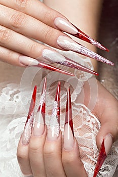 Long beautiful manicure with lace on female fingers. Nails design. Close-up photo