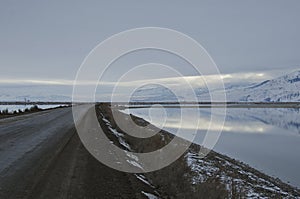 The long bending dirt road in the cold tundra