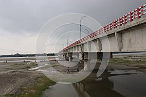 Long Big concrete bridge.An elevated concrete highway spanning across a Dark cloudy sky.view under the grey briage in the city. photo