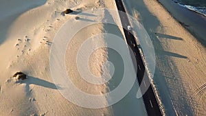 Long black asphalt road in the middle of the desert with nature and outdoors around