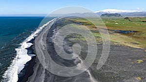 Long black beach seen from the Dyrholaey promontory with Eyafjiallajokull volcano in the background photo
