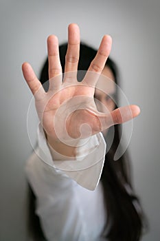 Long black hair asian woman rises her hand up to stop something