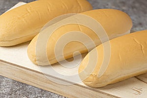 Long breads for hot dog on wood plate