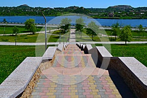 A long brick, stone staircase descends to the blue river. Summer photography