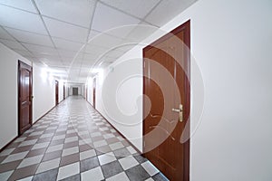 Long bright hallway with wooden doors and floor
