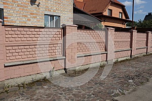 long brown brick fence on a city street