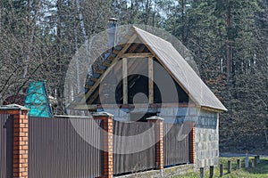 Long brown private fence and unfinished rural brick house