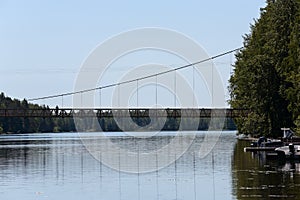 A long cable bridge over a sunny river