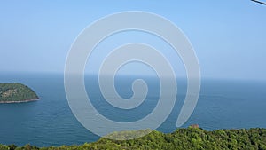 long cable car above mountain on island in sunset and old fishing town below under cloudy blue sky in Phu Quoc island