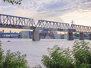 Long cargo train moving along the urban bridge over  Dnipro river in Kyiv, Ukraine