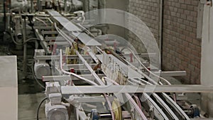 long ceramic tiles are transporting in conveyor belt in workshop, turning automatically